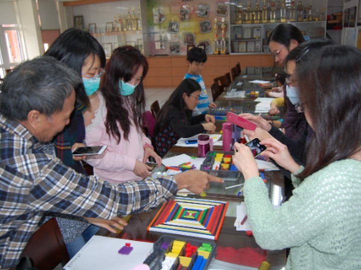 教師圍桌操作生活數學教具，與講師近距離互動